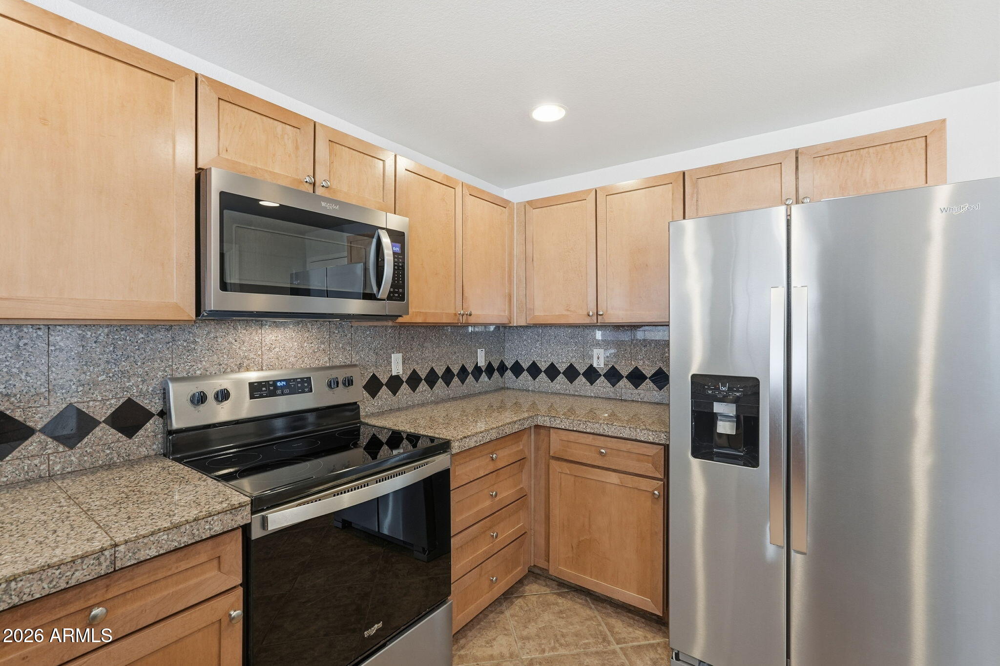 3150 East Beardsley Road, Unit 1064 Phoenix, AZ 85050 - Photo 11 of 30 a kitchen with stainless steel appliances granite countertop a refrigerator stove and microwave