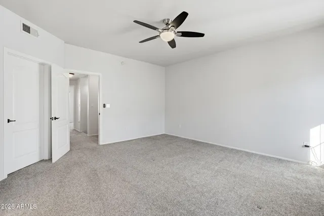 an empty room with closet and windows