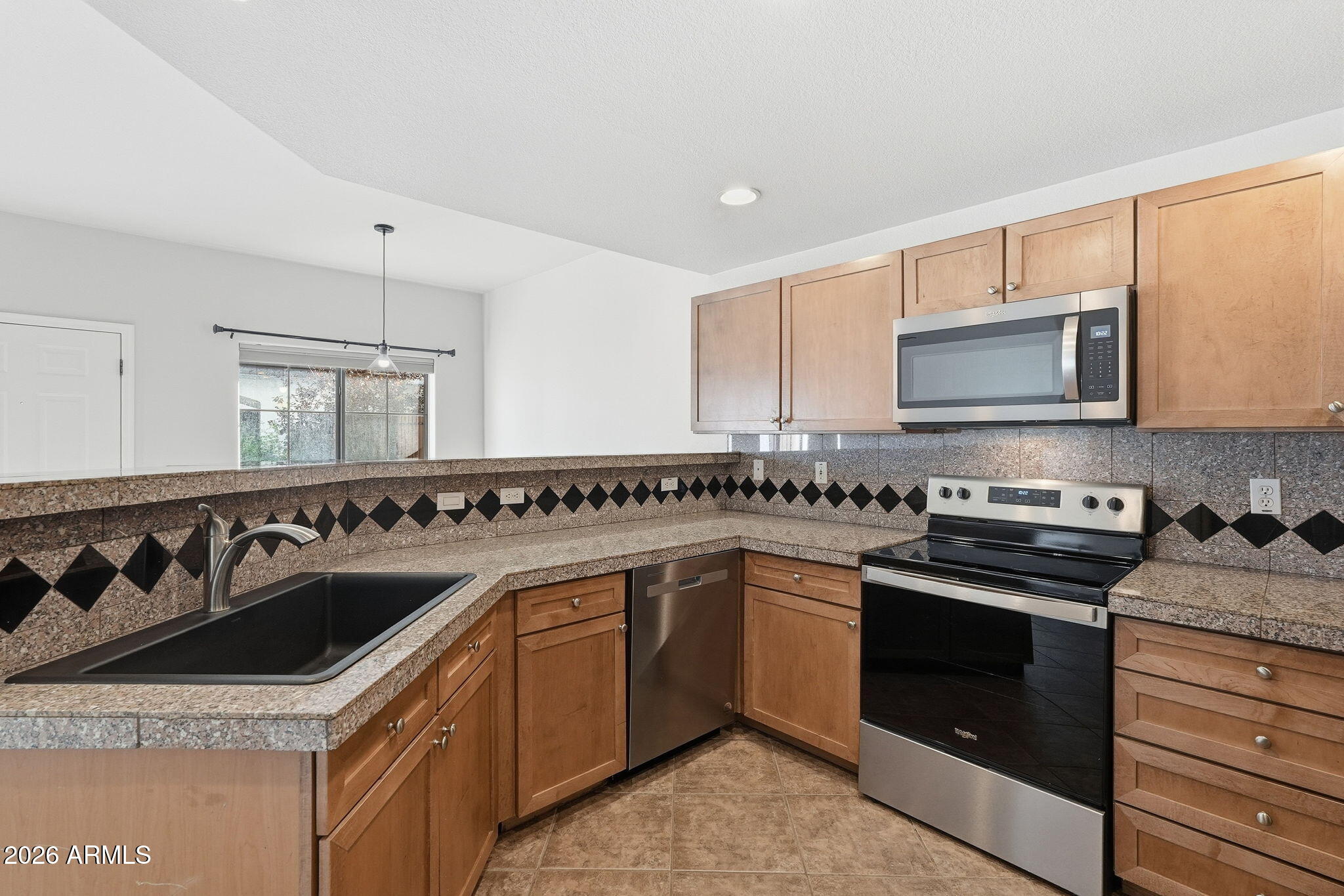 3150 East Beardsley Road, Unit 1064 Phoenix, AZ 85050 - Photo 8 of 30 a kitchen with granite countertop a sink and a stove top oven