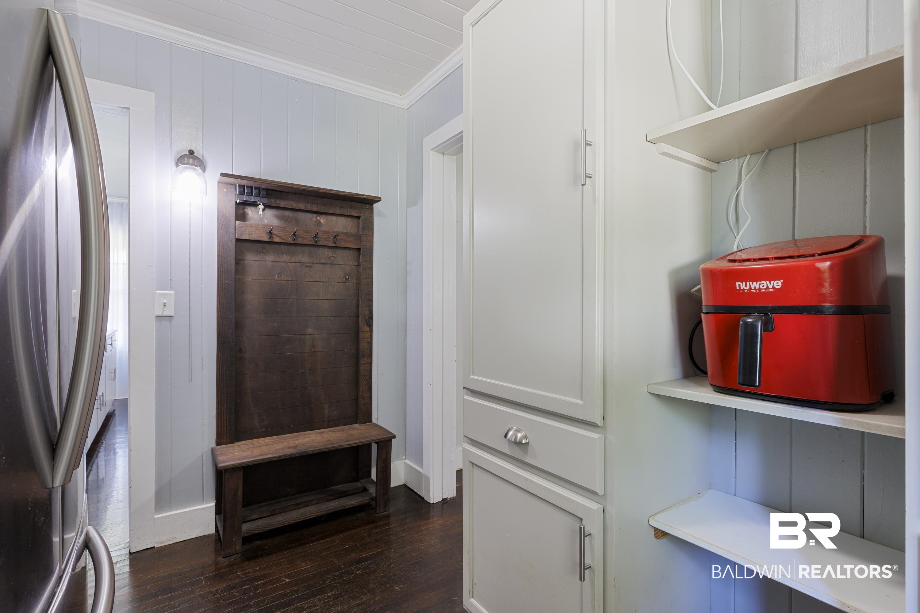 208 Beck Street Atmore, AL 36502 - Photo 17 of 26 Detailed view of freestanding refrigerator, crown molding, and wood finished floors