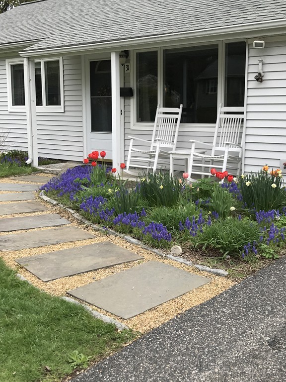 31 Elmfield Road Framingham, MA 01701 - Photo 3 of 25 a white house with flower garden in front of it
