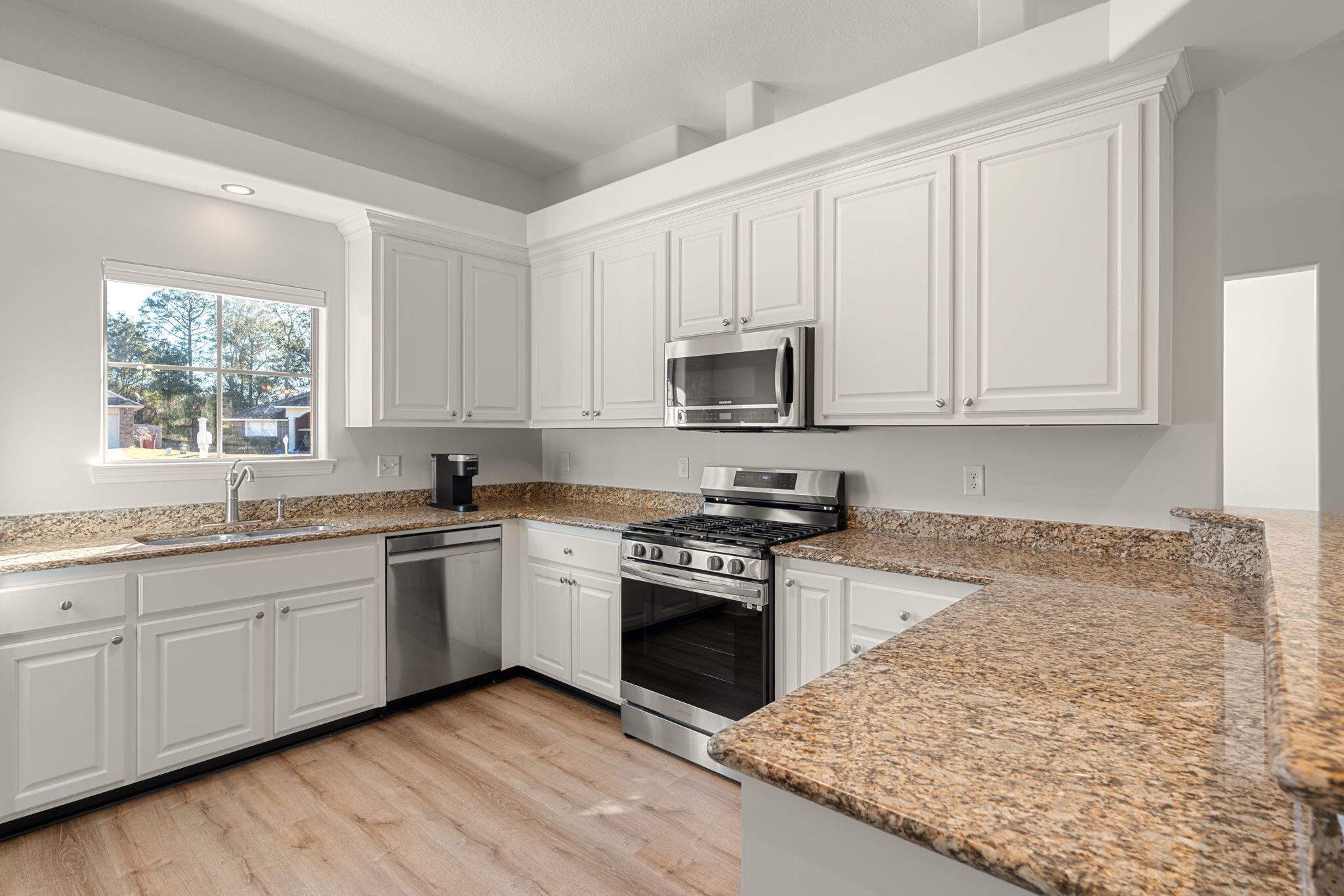 207 Pinque Coat Court Crestview, FL 32536 - Photo 5 of 47 a kitchen with stainless steel appliances granite countertop a stove a sink and a microwave