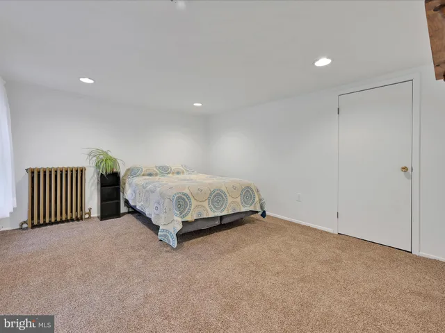 a spacious bedroom with a bed and a chandelier
