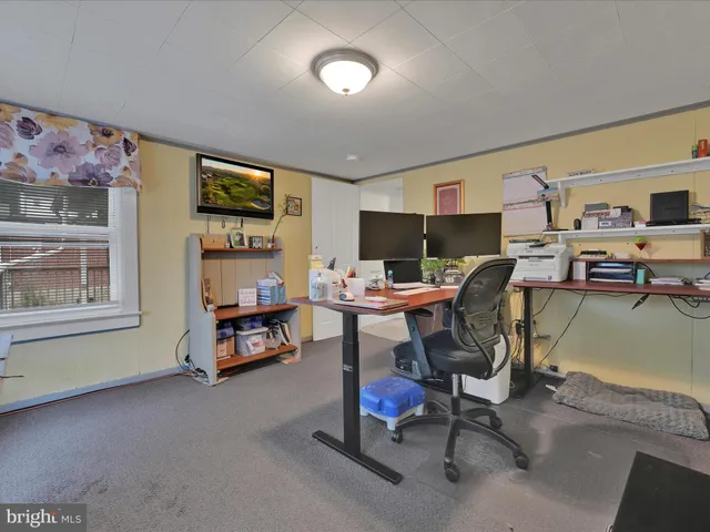 a view of a livingroom with workspace and a window