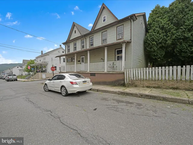 a car parked in front of white house