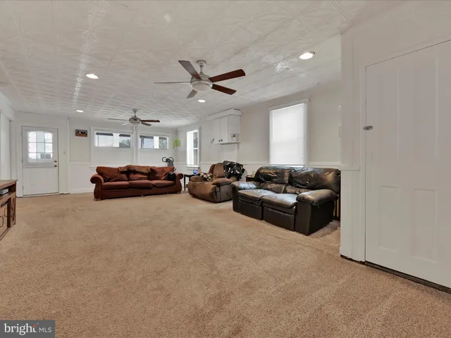 a living room with furniture a ceiling fan and a rug
