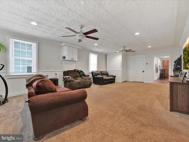 a living room with furniture a ceiling fan and a window