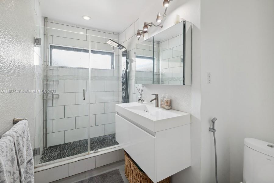 3531 Southwest 13th Street Miami, FL 33135 - Photo 13 of 25 a bathroom with a shower a sink and mirror