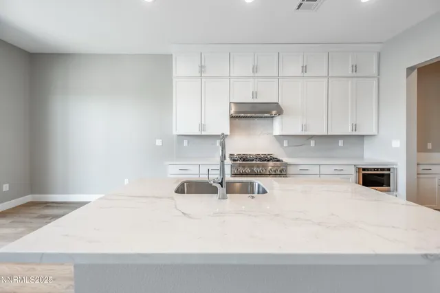 a kitchen with granite countertop white cabinets and white appliances