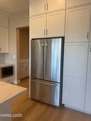 a metallic refrigerator freezer sitting in a kitchen