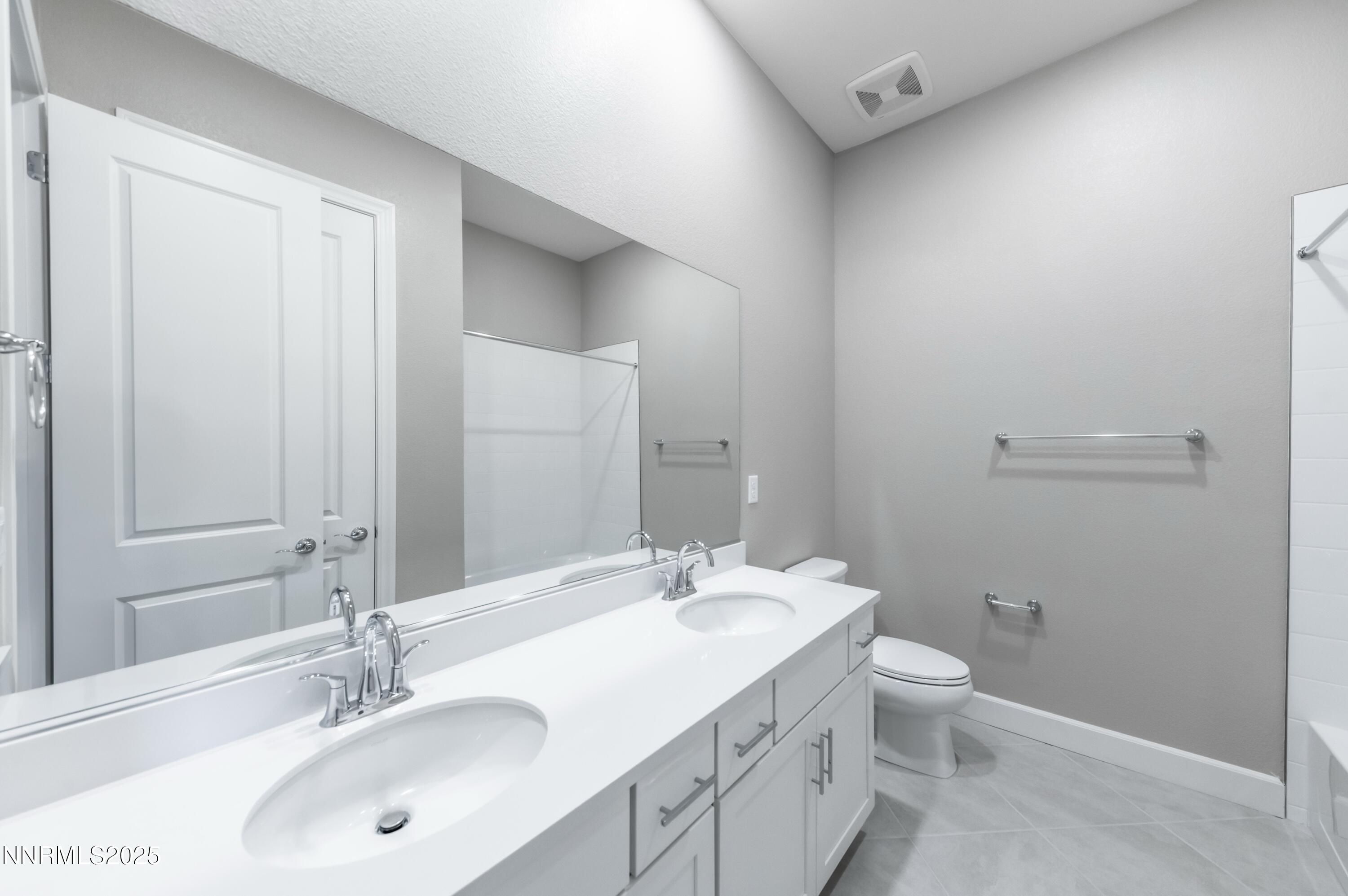 1517 Golf Club Drive Reno, NV 89519 - Photo 32 of 49 a bathroom with a granite countertop sink a toilet and a mirror