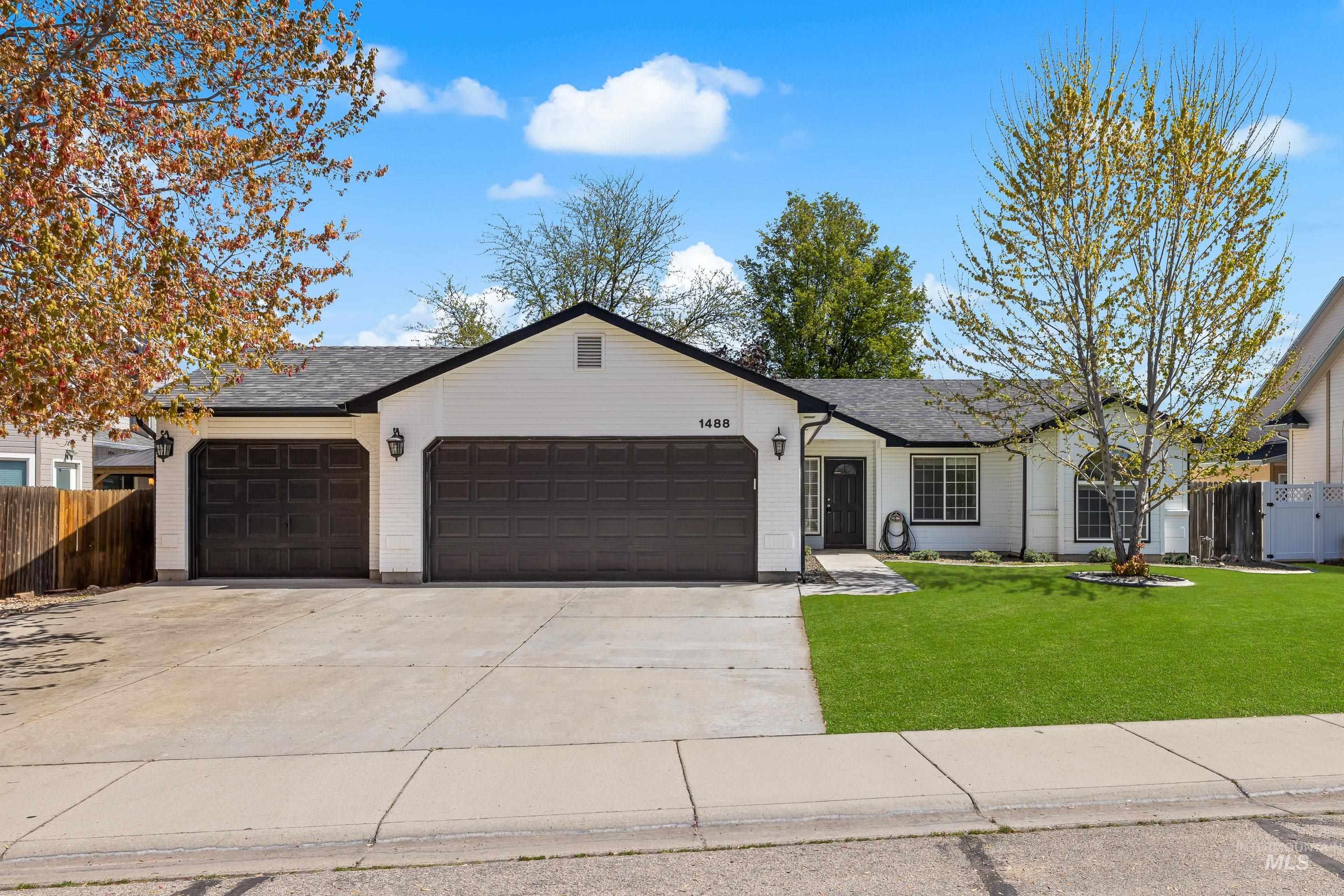 1488 North Lauderhill Way Meridian, ID 83642 - Photo 1 of 1 Contemporary ranch-style residence featuring white siding, a dark roof, and a two-car garage with dark paneled doors