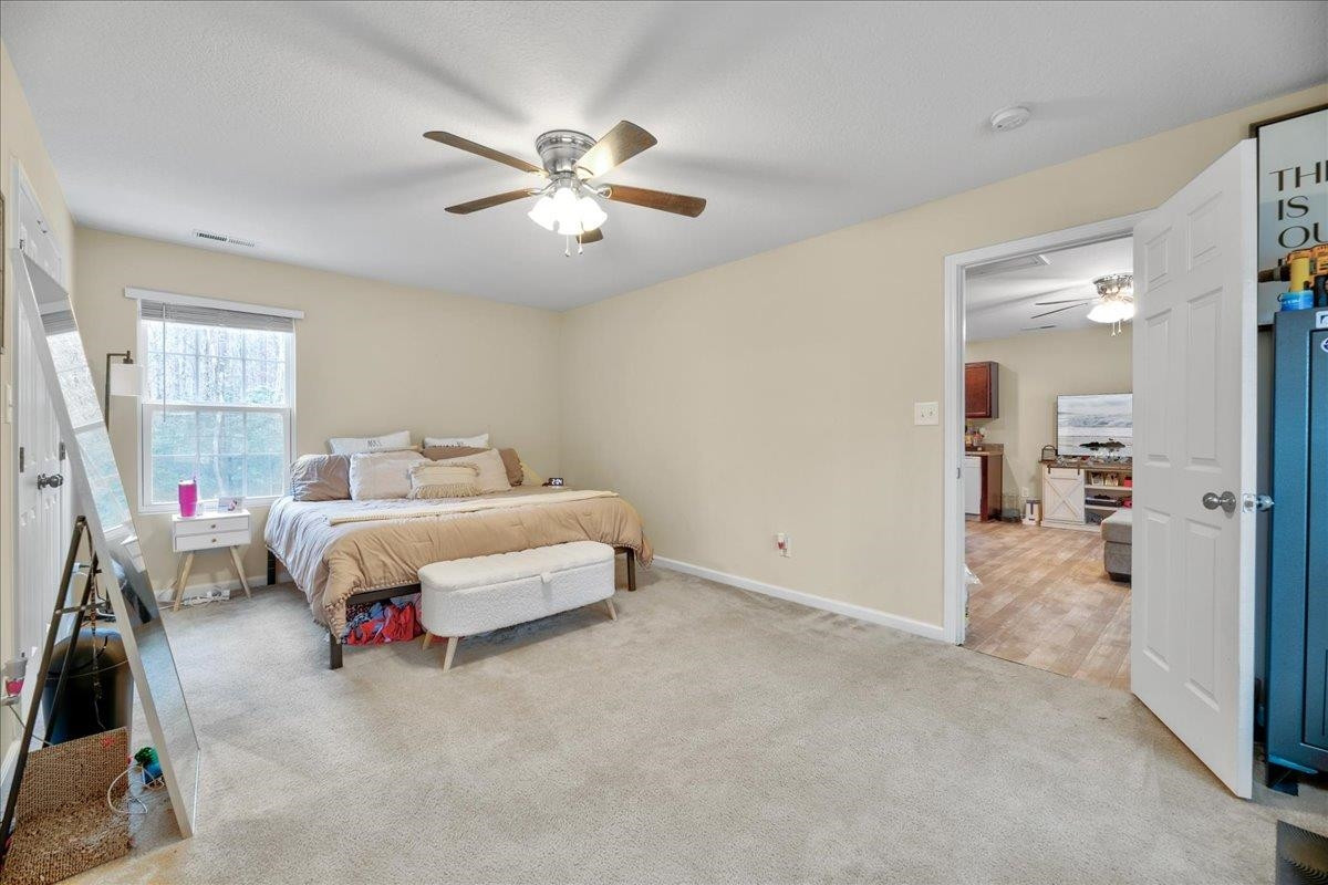 433 Scott Road Cameron, NC 28326 - Photo 44 of 55 a spacious bedroom with a bed and a chandelier