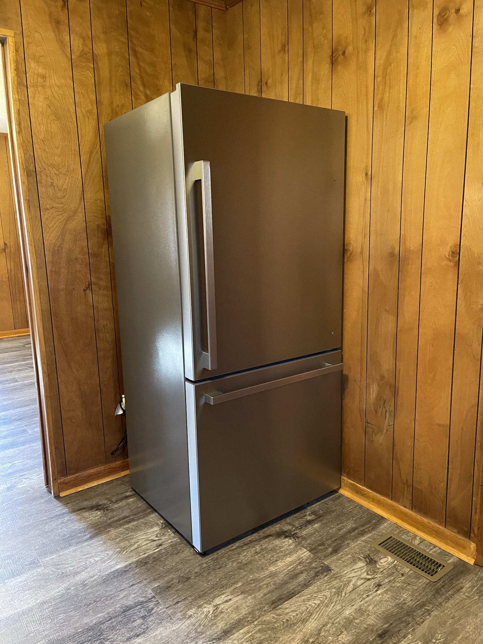 470 Cat Creek Road Manchester, TN 37355 - Photo 5 of 20 a view of a refrigerator in kitchen and an empty room with wooden floor