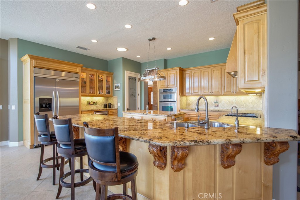 41380 La Sierra Road Temecula, CA 92591 - Photo 15 of 72 a kitchen with stainless steel appliances granite countertop a table and chairs