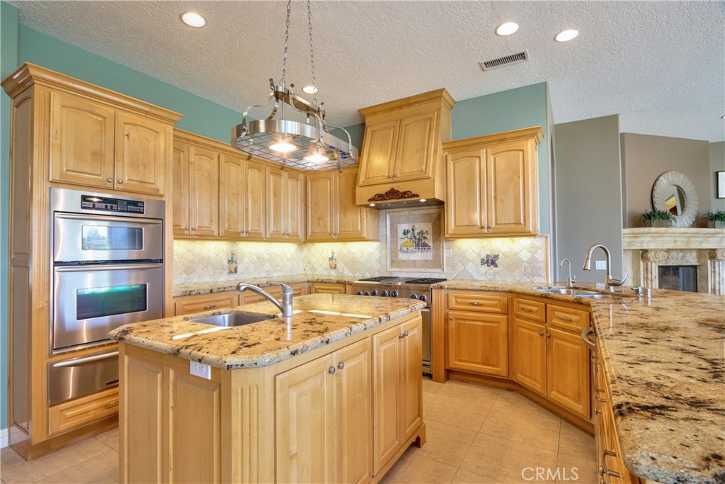 41380 La Sierra Road Temecula, CA 92591 - Photo 16 of 72 a kitchen with stainless steel appliances granite countertop a sink a stove and a refrigerator