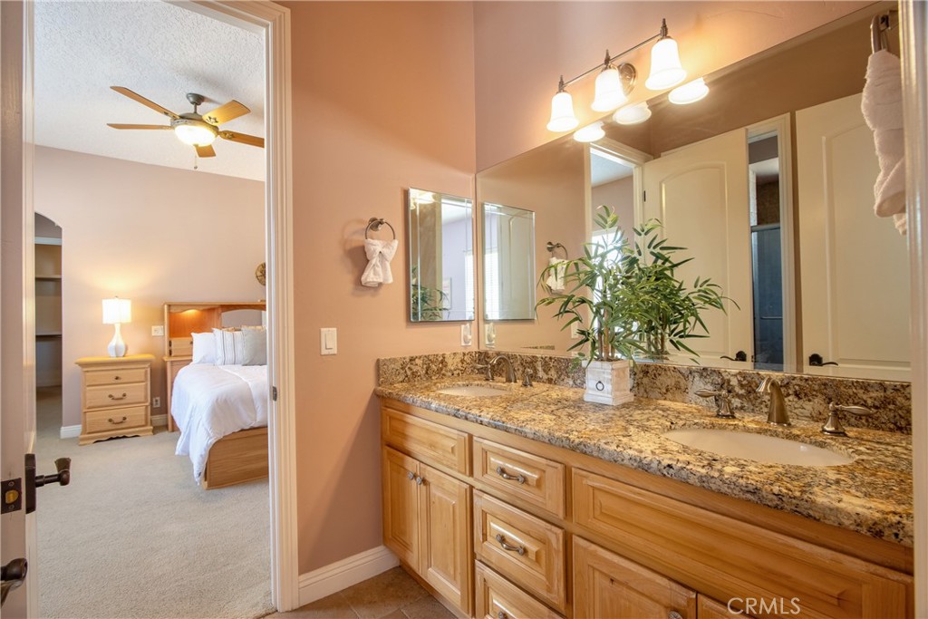 41380 La Sierra Road Temecula, CA 92591 - Photo 33 of 72 a bathroom with a granite countertop sink a large mirror and a shower