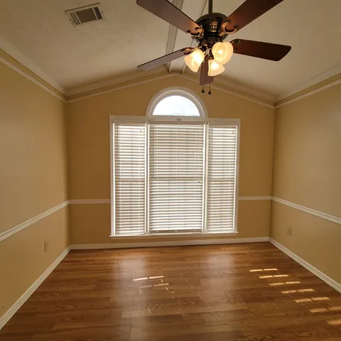 a room with a table chairs and a wooden floor