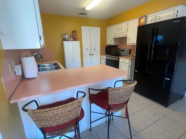 a living room with furniture a lamp and large window