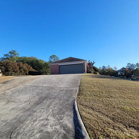 a view of a dry yard with wooden fence