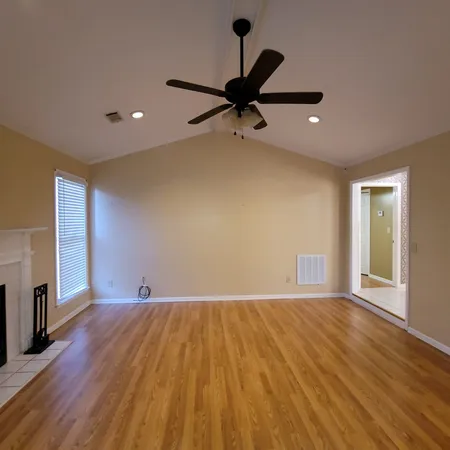an empty room with windows and fireplace