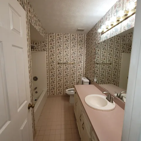 an empty room with a window and a ceiling fan