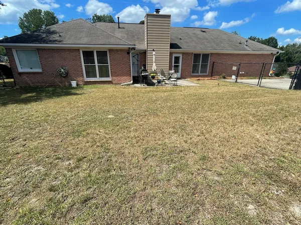 a view of a house with a yard and sitting area