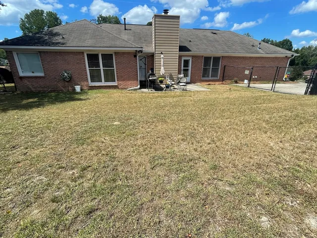 a view of a house with a yard and sitting area