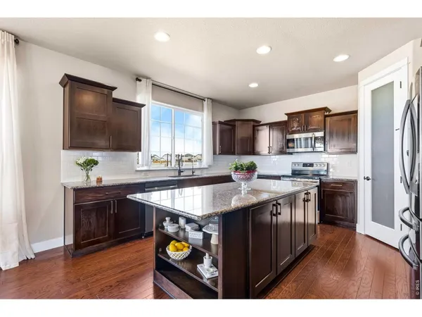 a kitchen with kitchen island granite countertop a sink stove and refrigerator