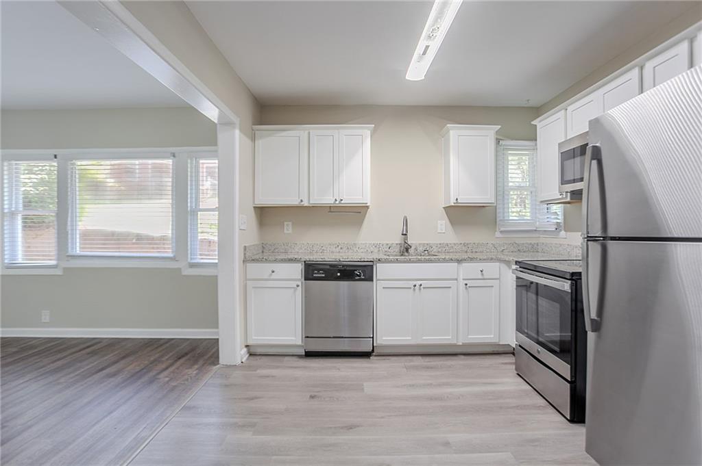 2755 Rockcliff Road Southeast Atlanta, GA 30316 - Photo 4 of 37 a kitchen with a refrigerator stove and wooden cabinets