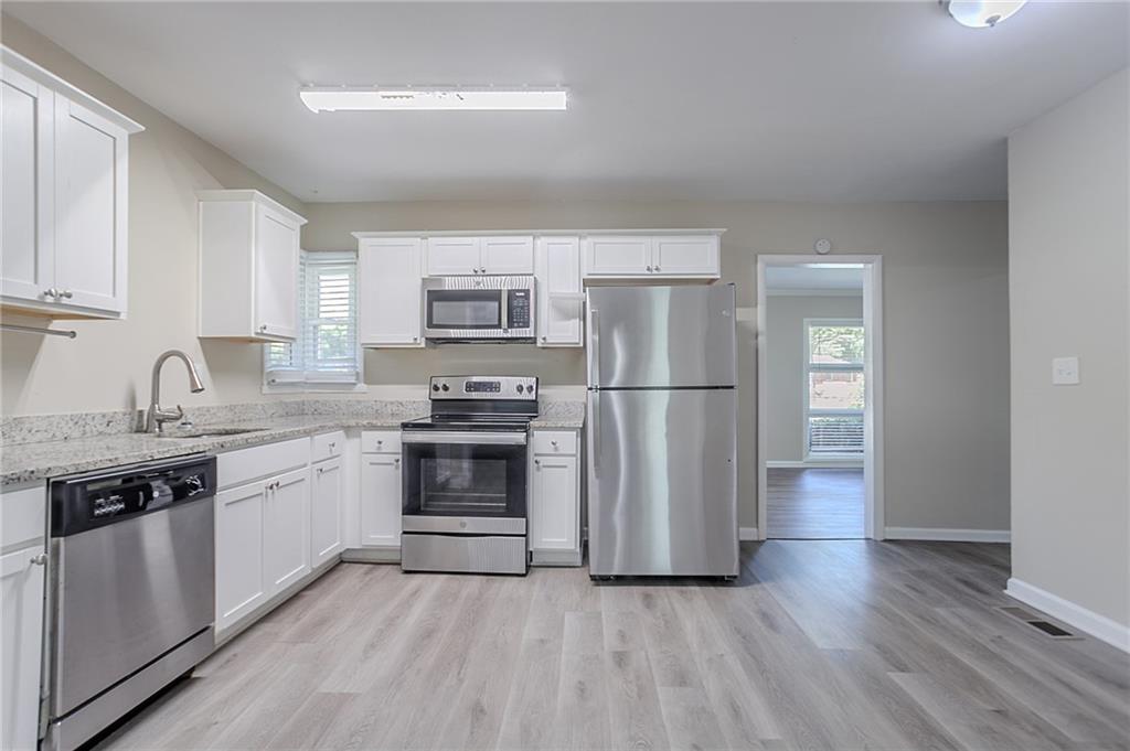 2755 Rockcliff Road Southeast Atlanta, GA 30316 - Photo 5 of 37 a kitchen with granite countertop a refrigerator stove and sink
