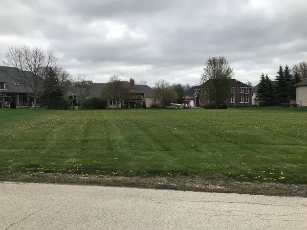 a view of a big yard with a house in the background