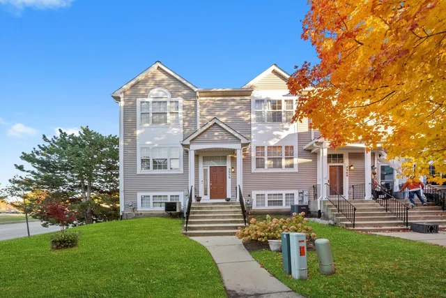 a front view of a house with a garden and plants
