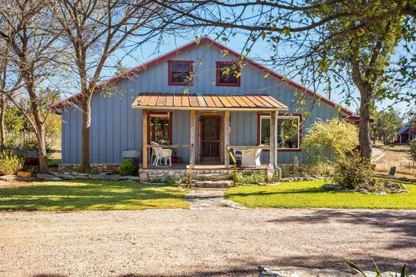 a bedroom with a bed a chandelier and a window