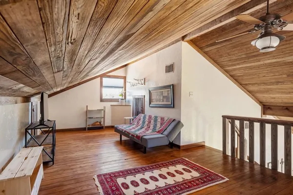 a living room with furniture a wooden floor and next to a window