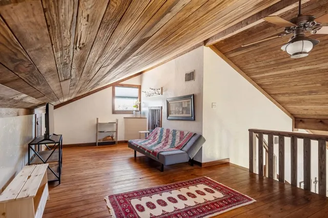a living room with furniture a wooden floor and next to a window