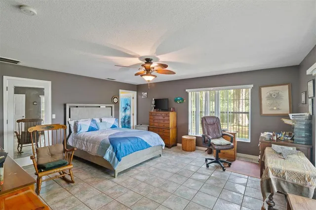 a bedroom with a bed and large windows