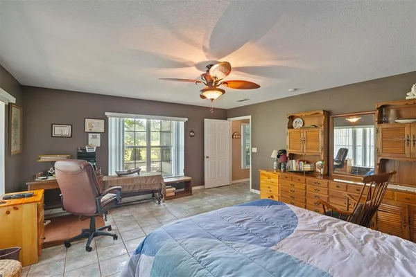 a view of a bedroom with workspace and windows