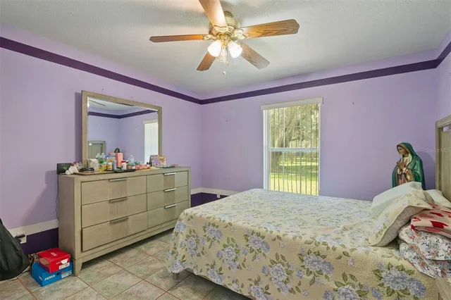 a bedroom with a bed and a mirror on dresser
