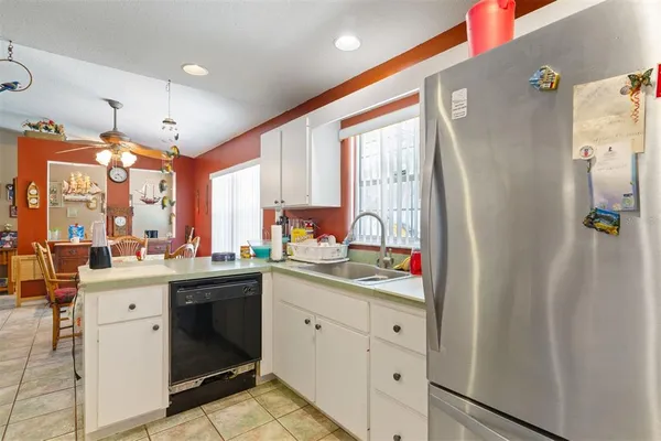 a kitchen with white cabinets and sink