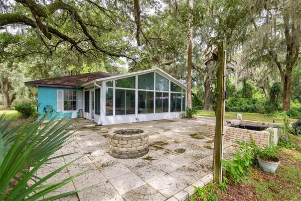 a view of a house with backyard sitting area and garden