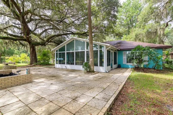 a view of a house with backyard and sitting area