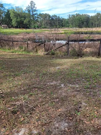 a view of dirt field with trees