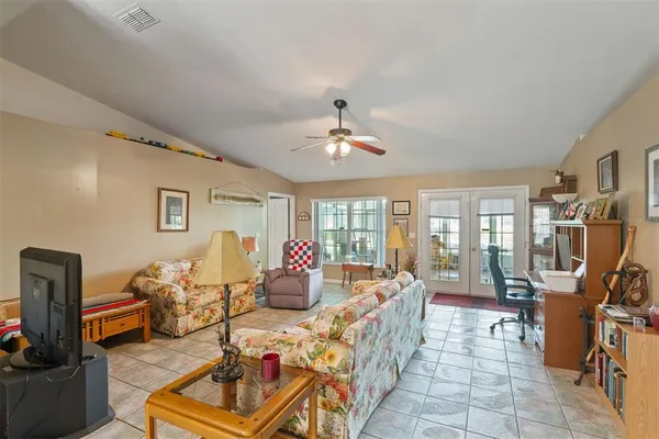 a living room with furniture a chandelier and a flat screen tv