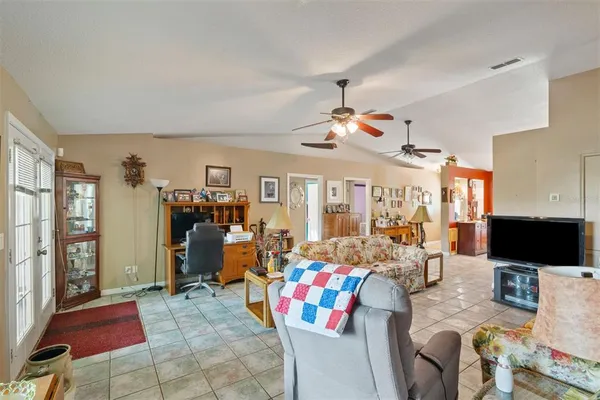 a living room with furniture a flat screen tv and a floor to ceiling window