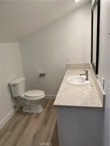a bathroom with a granite countertop toilet a sink and a mirror