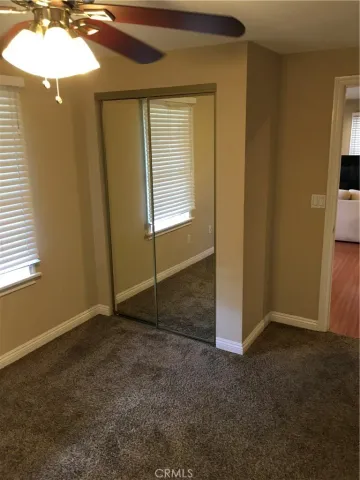 an empty room with an entryway and chandelier fan