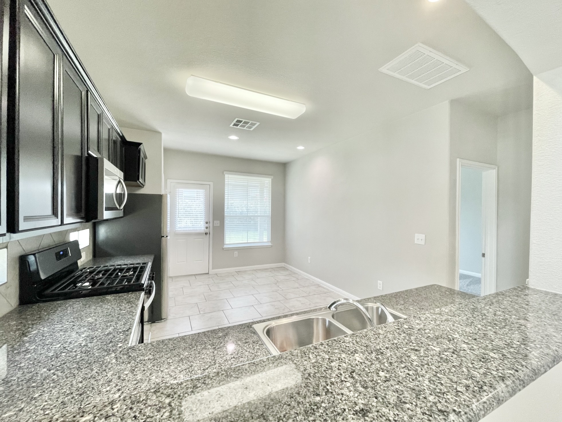 407 Rhetoric Way Pflugerville, TX 78660 - Photo 9 of 38 a view of a livingroom with wooden floor and kitchen space