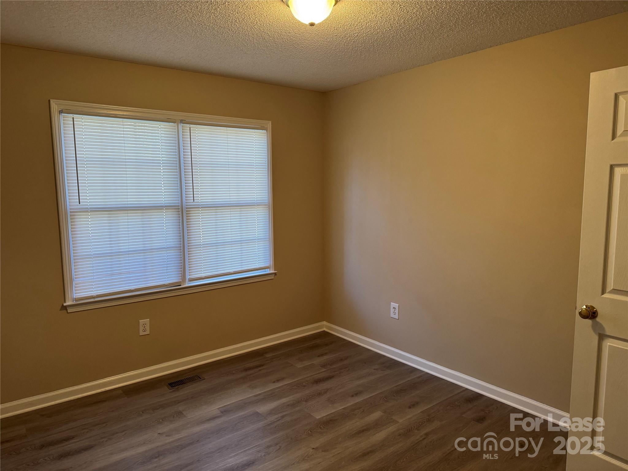 1424 Ridgewood Drive Concord, NC 28027 - Photo 13 of 14 a view of an empty room with wooden floor and a window