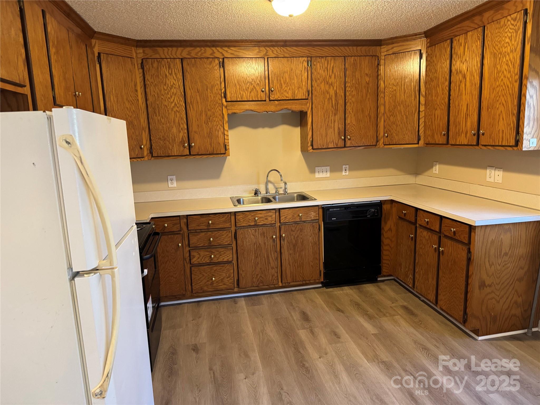 1424 Ridgewood Drive Concord, NC 28027 - Photo 5 of 14 a kitchen with a refrigerator and a sink